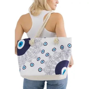 Woman carrying a tote bag with a blue and white evil eye mati pattern on a white background