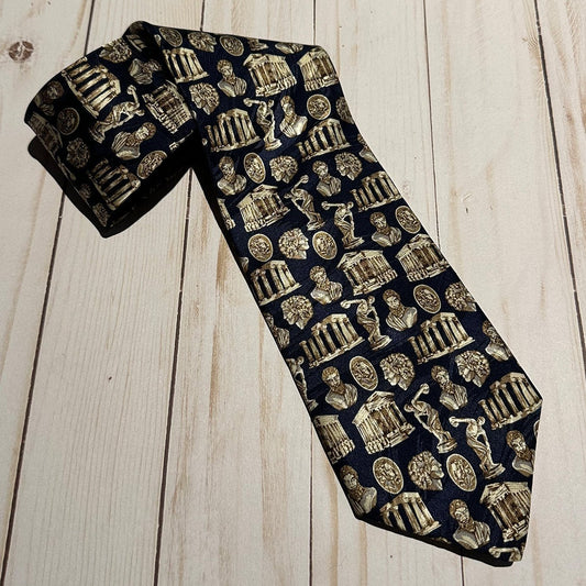 Navy blue tie with gold architectural and classical figures pattern on a wooden surface