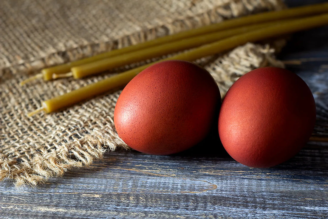 Traditional red hard boiled eggs near candles on table for Greek Orthodox Easter