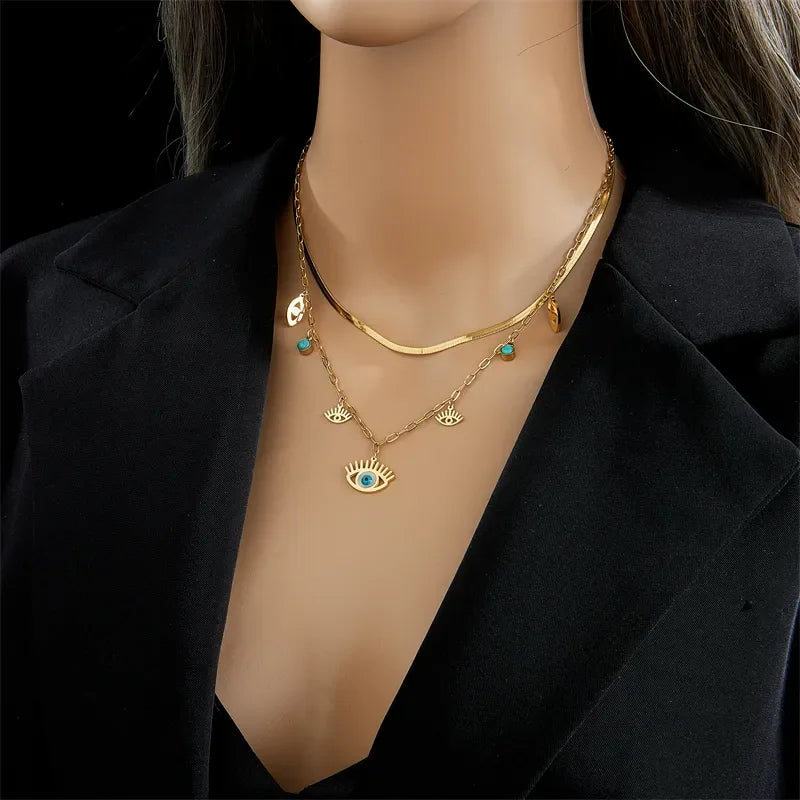 Mannequin wearing a gold necklace with eye-shaped pendants on a black background