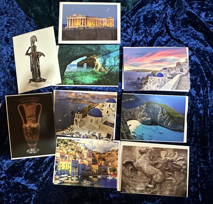 Collection of postcards featuring Greek landmarks and culture on a textured blue surface