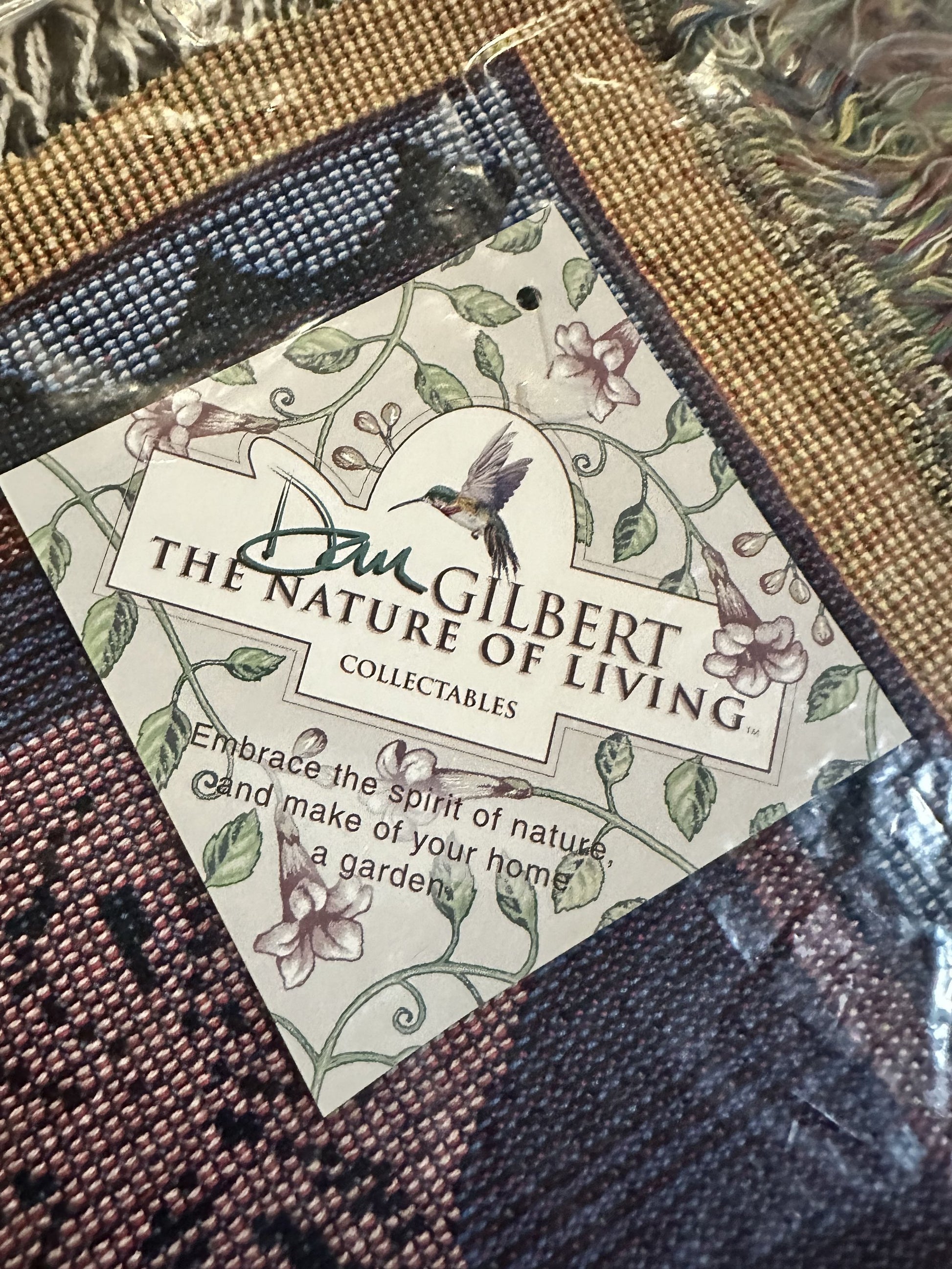 Porpoise Song Throw with 'Dan Gilbert The Nature of Living' label featuring a hummingbird design.