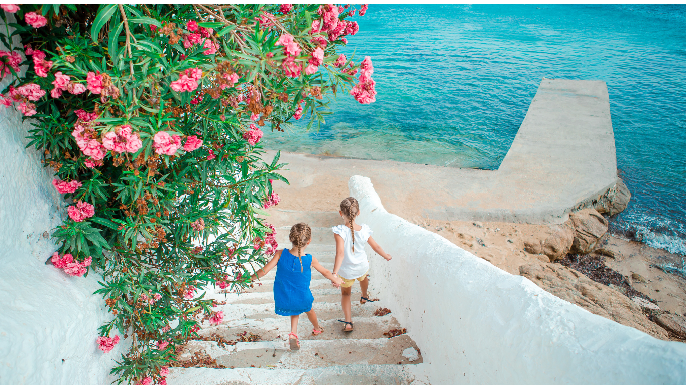 Two little blond girls going down stairs to Greek Beach