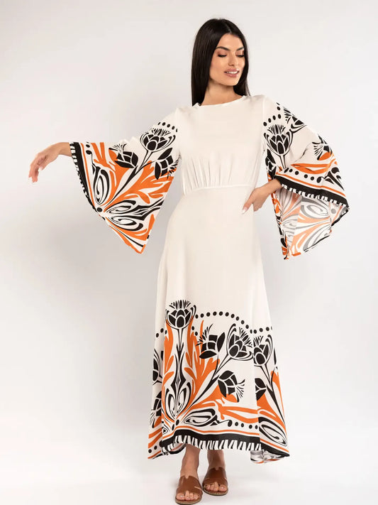Woman wearing a white dress with orange and black floral patterns on a white background