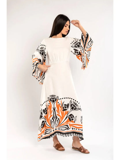 Woman wearing a white dress with black and orange floral patterns on a white background