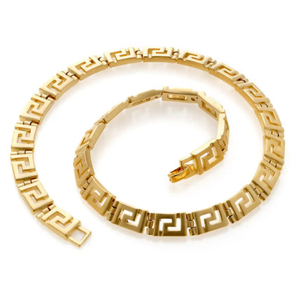 Gold necklace with intricate Greek Key Meander design on a white background