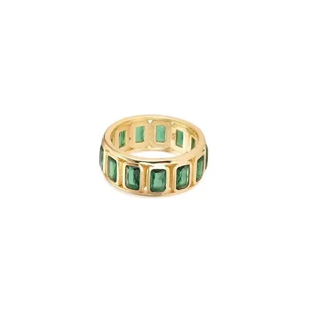 Gold ring with green gemstones on a white background