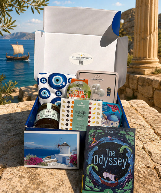 Gift box with Greek-themed items including a book titled 'The Odyssey' in front of a scenic background.