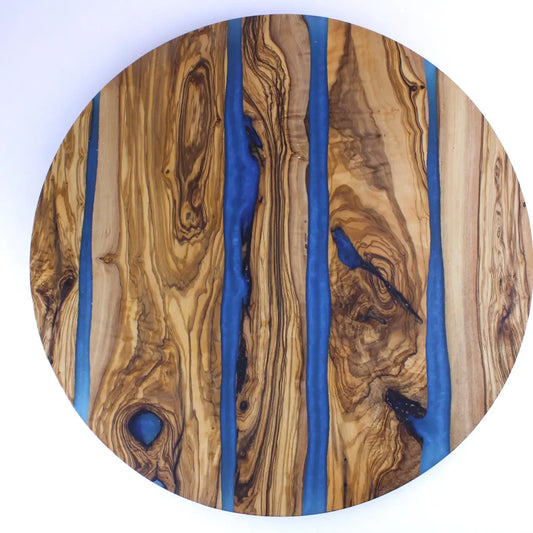 Round wooden lazy susan with blue resin inlay on a white background
