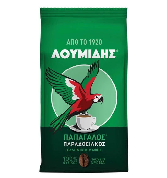 A green bag of Loumids Papadopoulos Paradosiakos Greek coffee, featuring a red and green parrot perched on a cup of coffee with white text on a white background.
