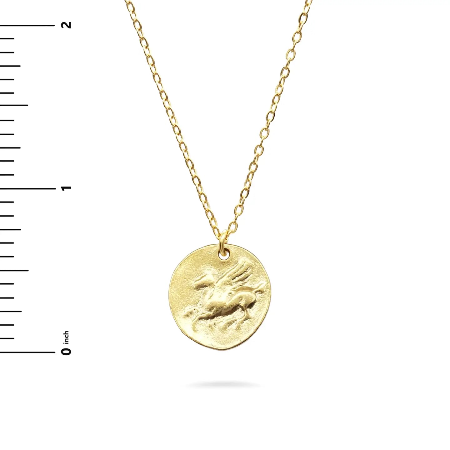 Gold necklace with a round Pegasus pendant  on a white background with a ruler for scale.