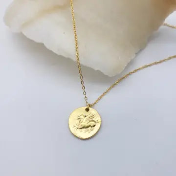 Gold necklace with a round Pegasus pendant on a light background
