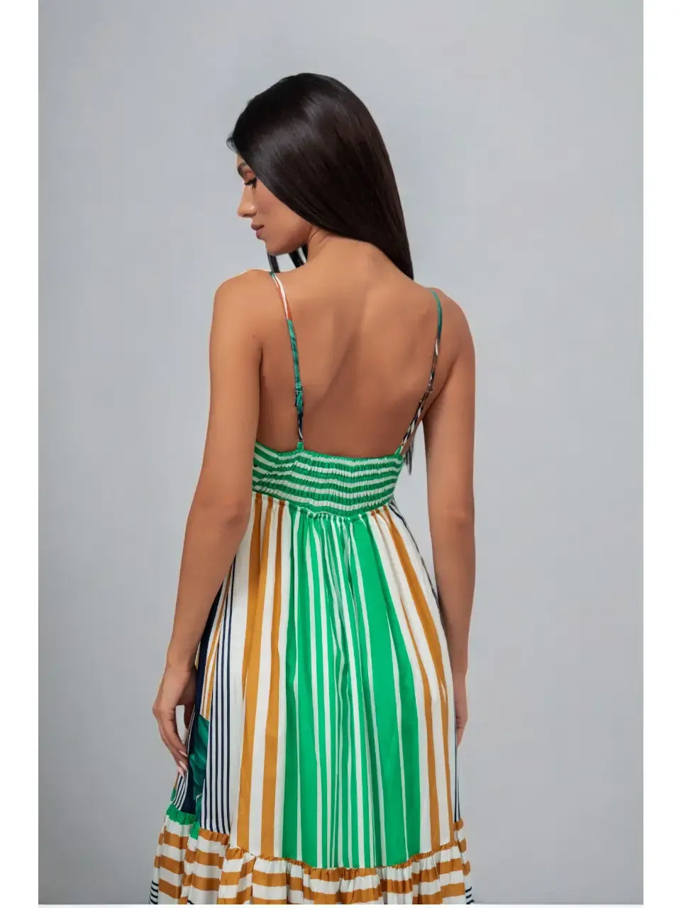 Woman wearing a green and multicolor striped dress against a gray background