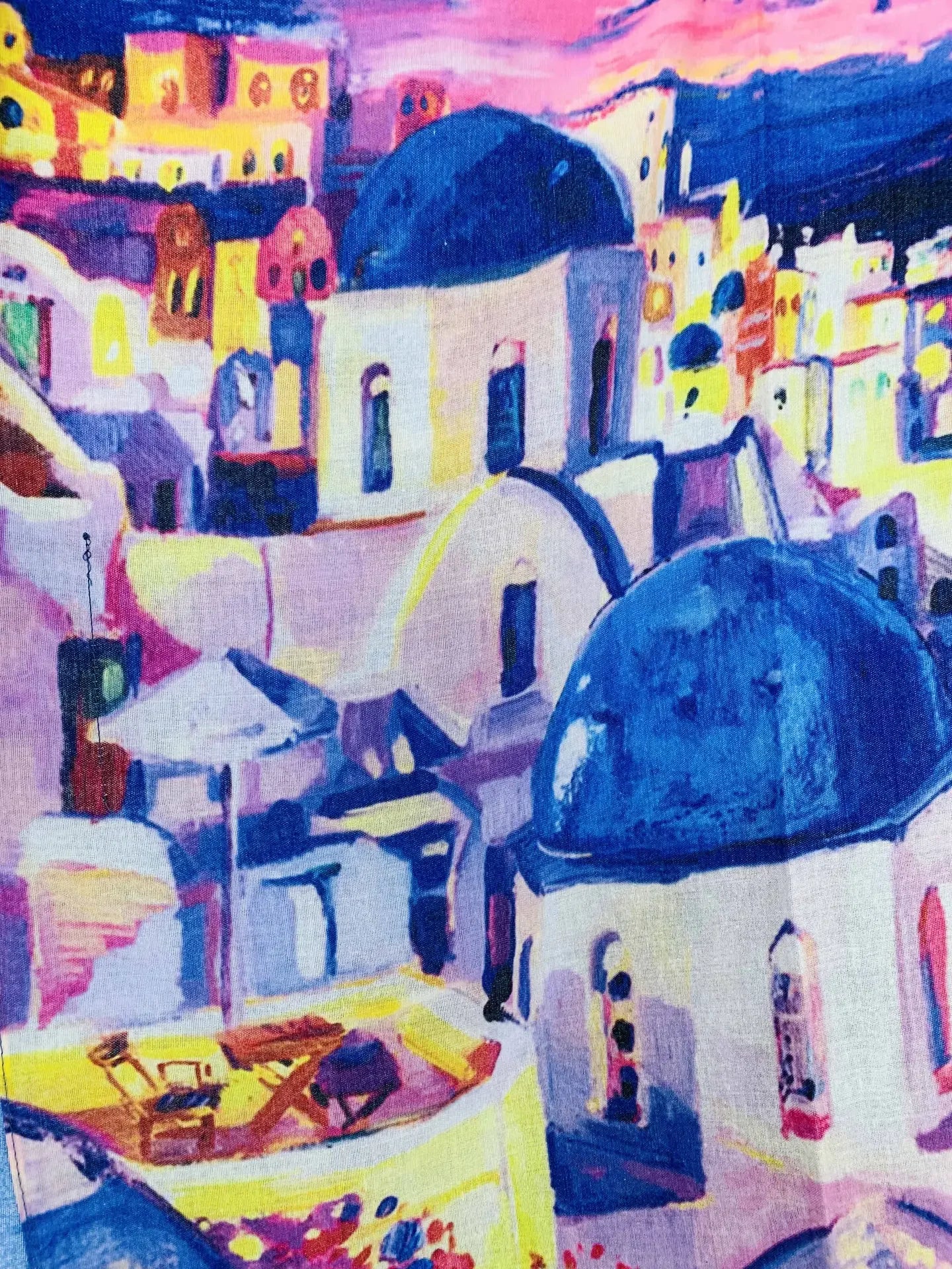 Pink sunset behind the blue domes of Santorini Greece on a beach cover up