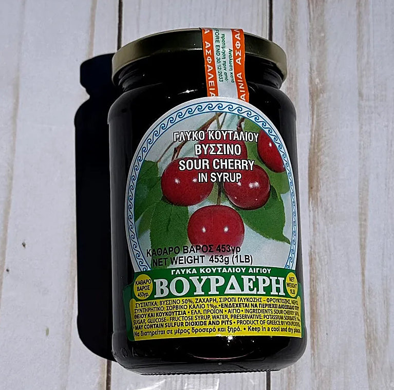 Jar of Vouderis sour cherry syrup on a wooden surface