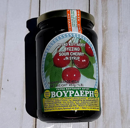 Jar of Vouderis sour cherry syrup on a wooden surface
