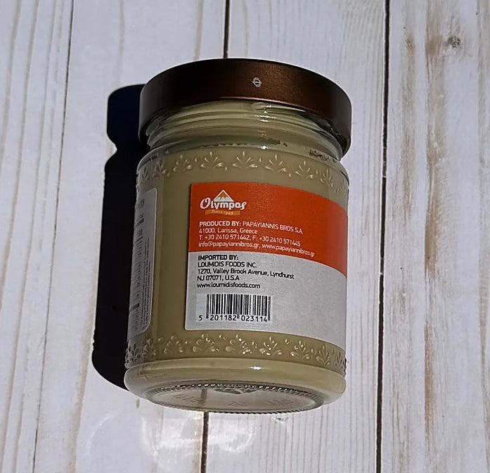 Olympos Tahini Jar with a label on a wooden surface