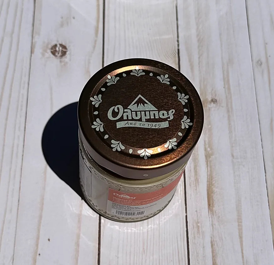 Olympos Tahini with a lid on a wooden surface