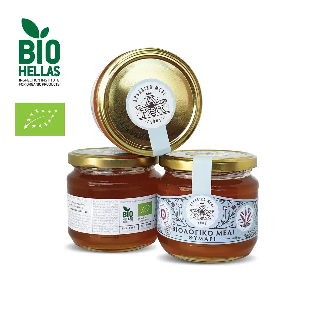 Three jars of honey with gold lids on a white background, featuring the Bio Hellas logo