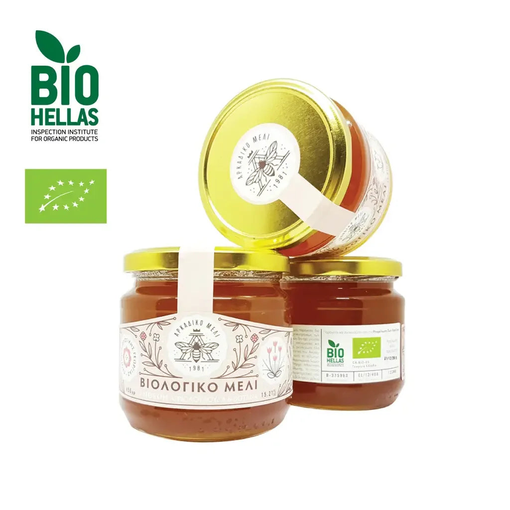 Three jars of honey with gold lids on a white background, featuring the Bio Hellas logo.