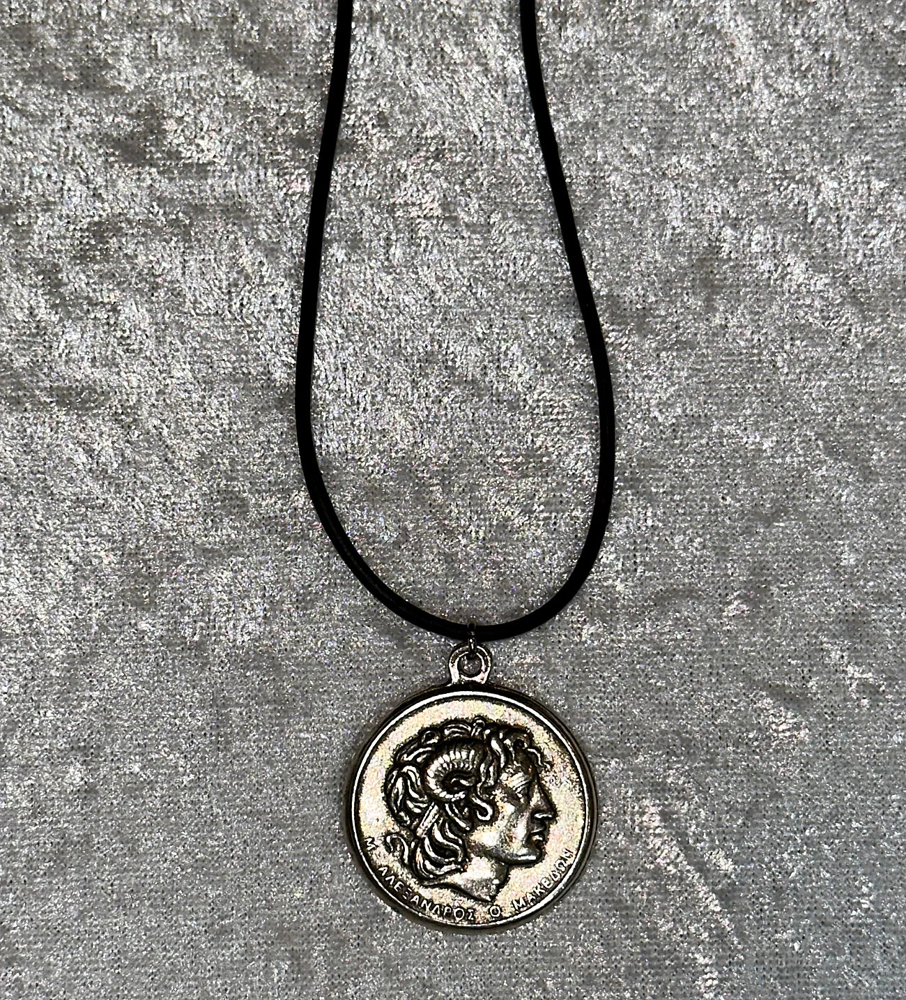Necklace with a coin pendant featuring Alexander the Great on a textured gray background