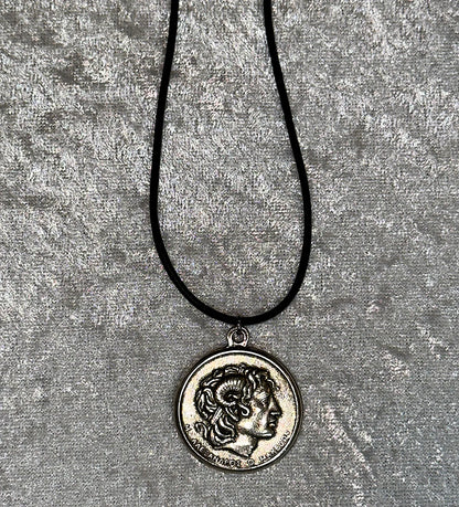 Necklace with a coin pendant featuring Alexander the Great on a textured gray background