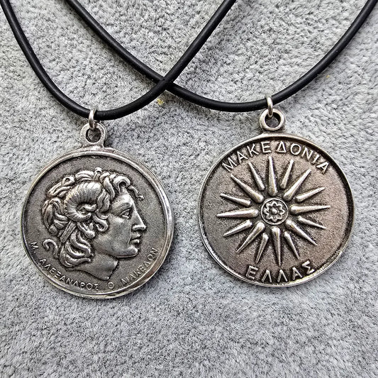 Two silver medallions on black cords against a textured gray background