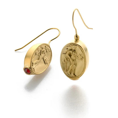 Aphrodite gold earrings with red gemstones on a white background