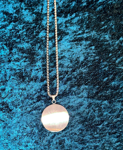 Necklace with a round pendant on a blue textured background