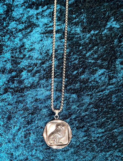 Silver necklace with a pendant on a textured blue background