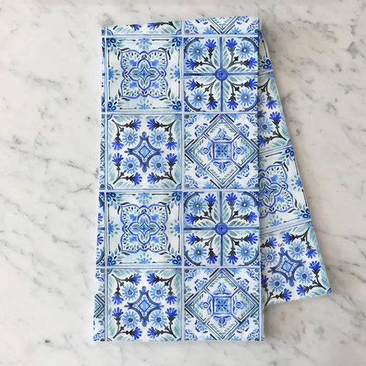 Folded fabric with blue and white geometric pattern on a marble surface