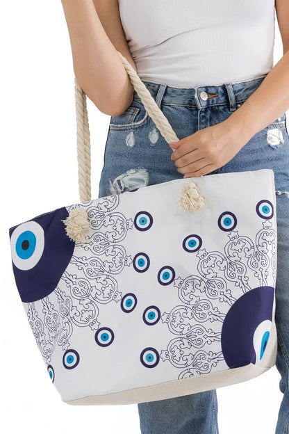 Lovely woman holding an evil eye tote bag with blue and white eye pattern at her hip