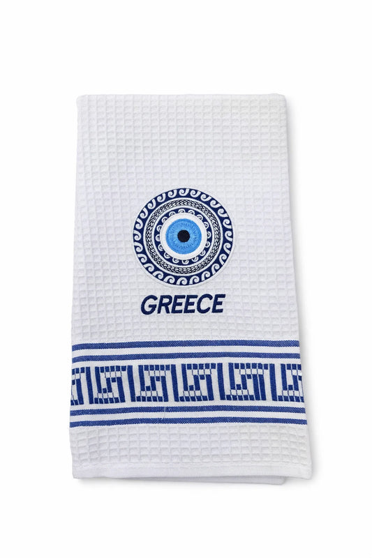 White towel with blue decorative elements, including a 'Mati' evil eye and 'Greece' text on a white background