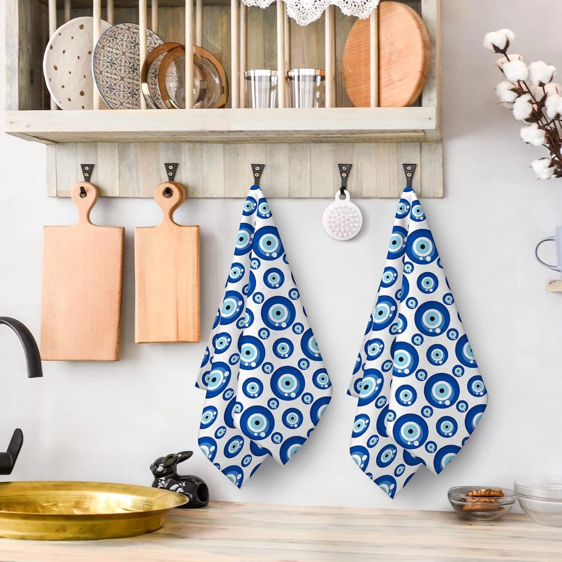 Blue and white patterned towels hanging on a wooden hook in a kitchen
