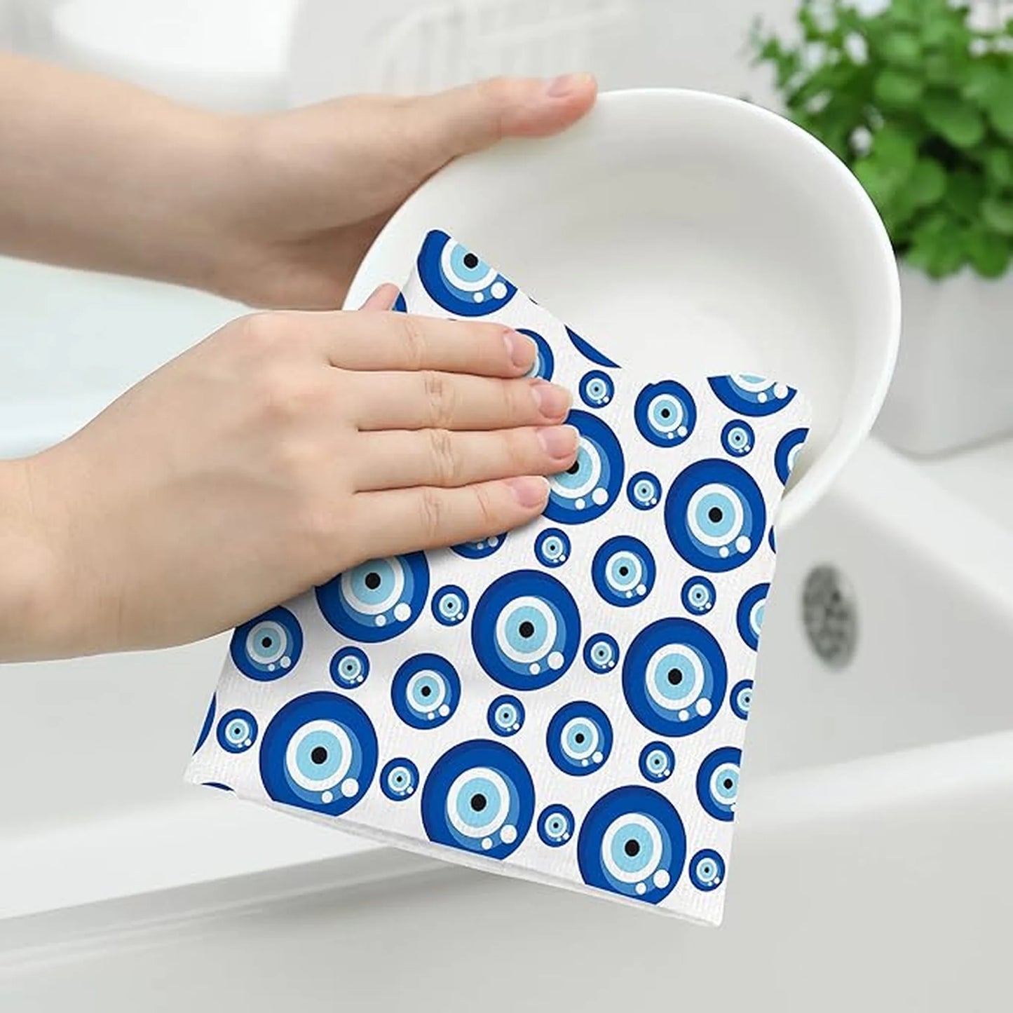 Person holding a white towel with blue circular patterns over a sink
