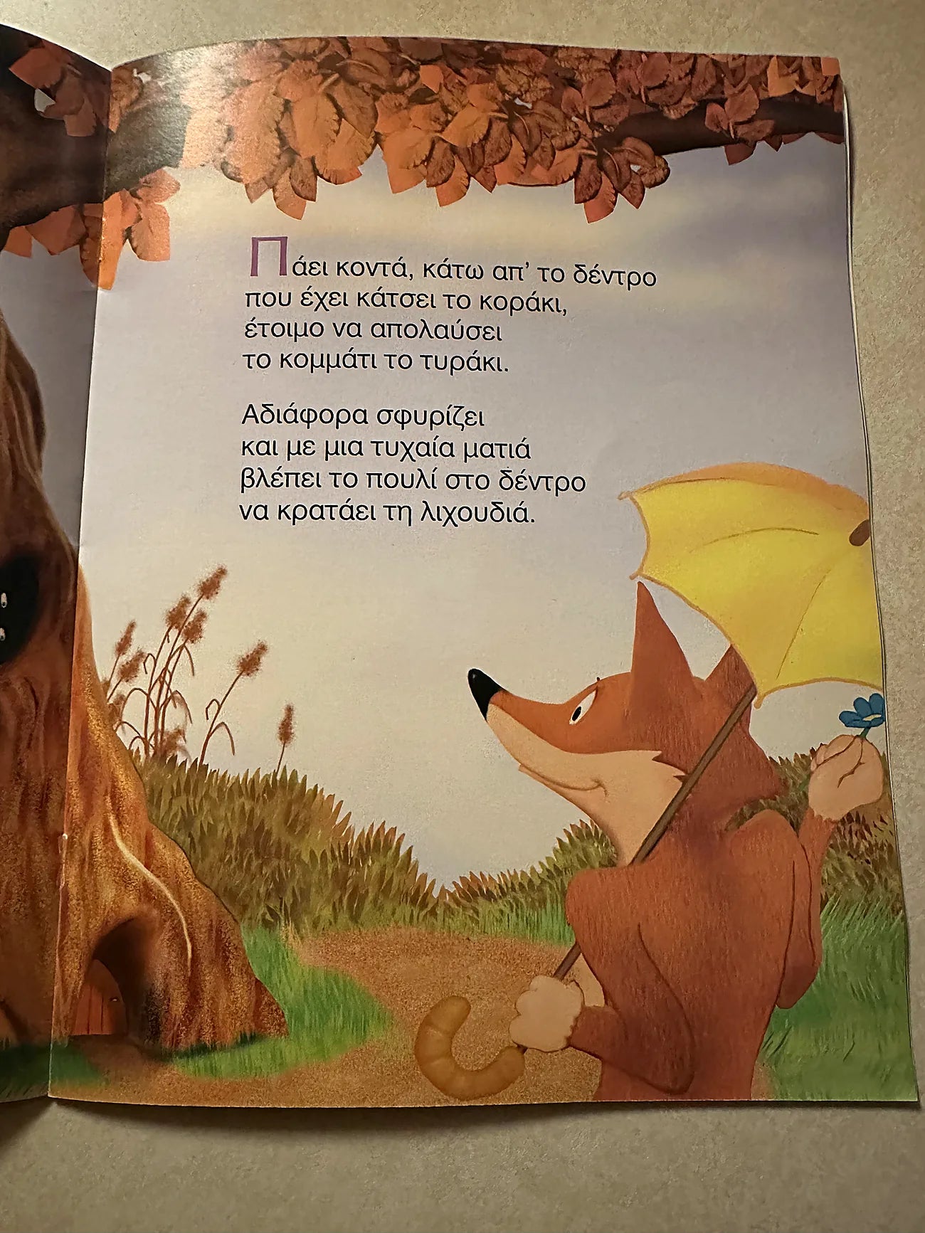 Illustrated book page with a fox holding an umbrella in a forest setting