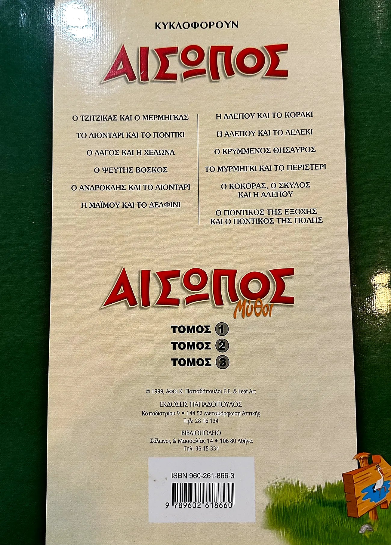 Back cover of a book titled 'Aesop' with Greek text and a cartoon character on a green background.