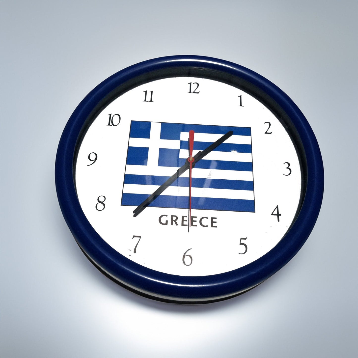 Wall clock with Greek flag design on a gray background