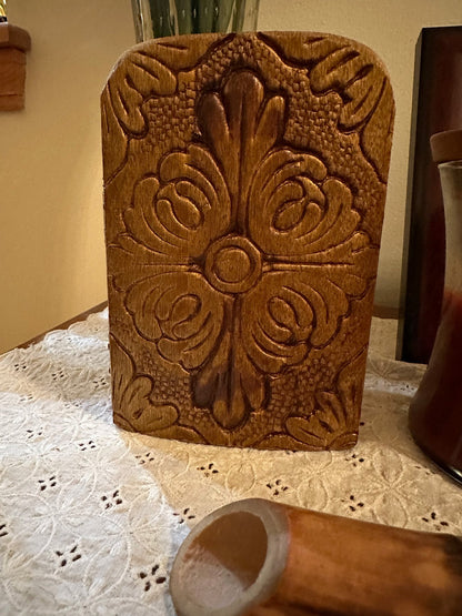 Front of wooden religious icon diptych with intricate design on a lace tablecloth