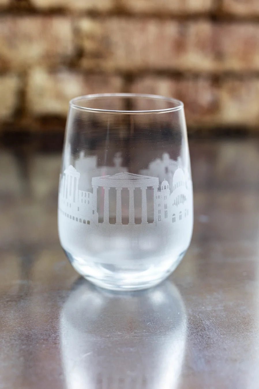 Clear glass with etched Greek architecture design on a reflective surface