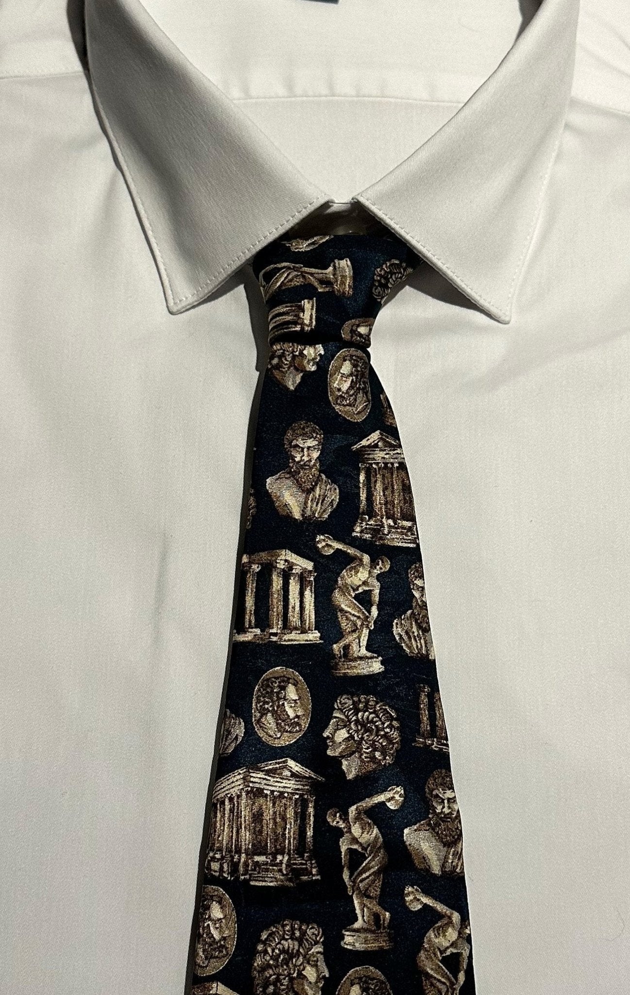 Teal tie with classical Greek sculpture and architecture design worn on a white shirt