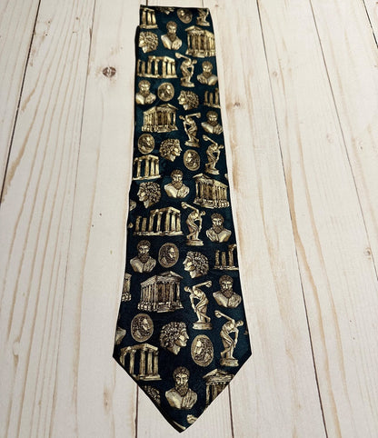 Teal tie with gold architectural and classical Greek figures pattern on a wooden surface