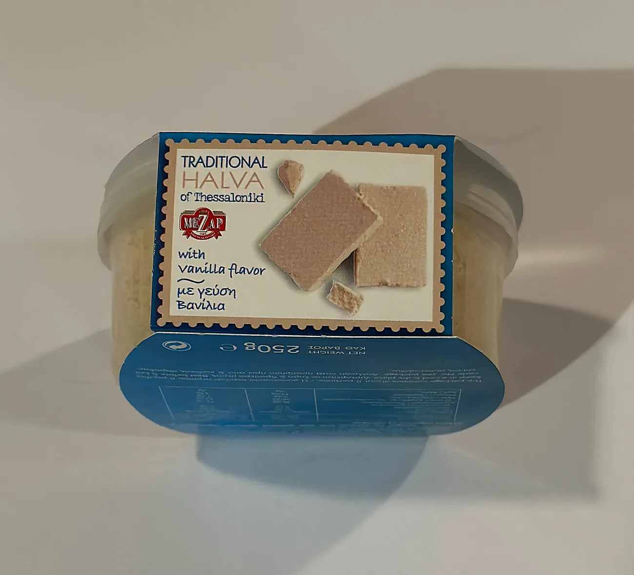 Container of halva with a blue label on a white background