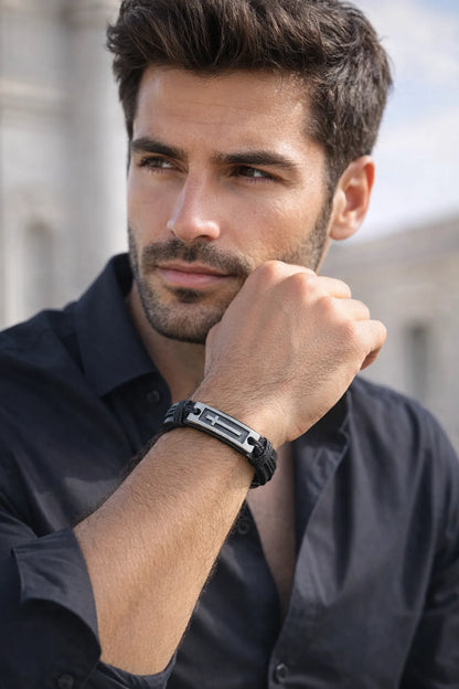 Handsome man wearing black leather bracelet with silver cross and black button down shirt