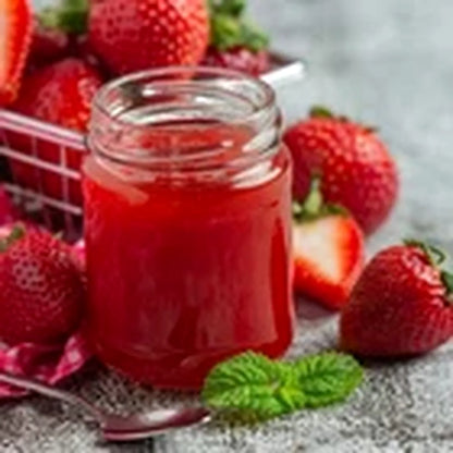 Jar of strawberry jam surrounded by fresh strawberries on a rustic surface
