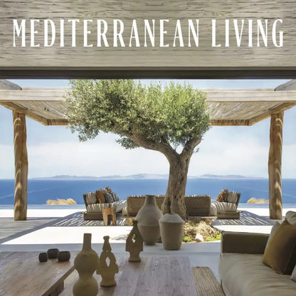 A lifestyle interior scene with the text 'MEDITERRANEAN LIVING' at the top, showing an open-air patio overlooking the sea with outdoor seating, a large tree, and decorative vases in the foreground.