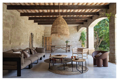 Modern living room with stone walls, wooden beams, and decorative furniture.