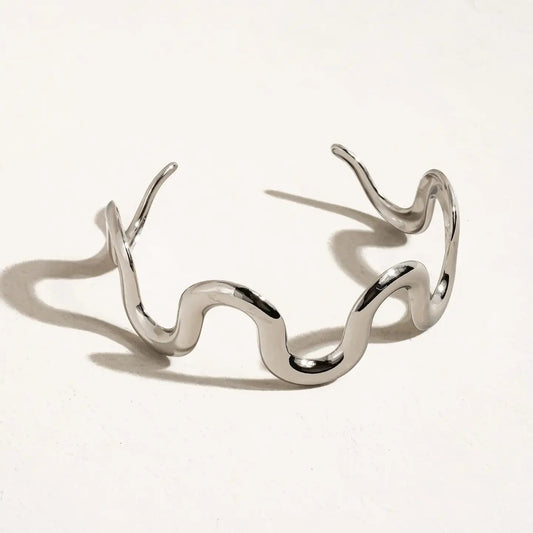 Silver wavy bracelet on a light gray background