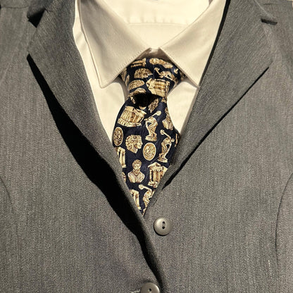 Close-up of a gray suit with a Greek architecture and sculpture patterned tie