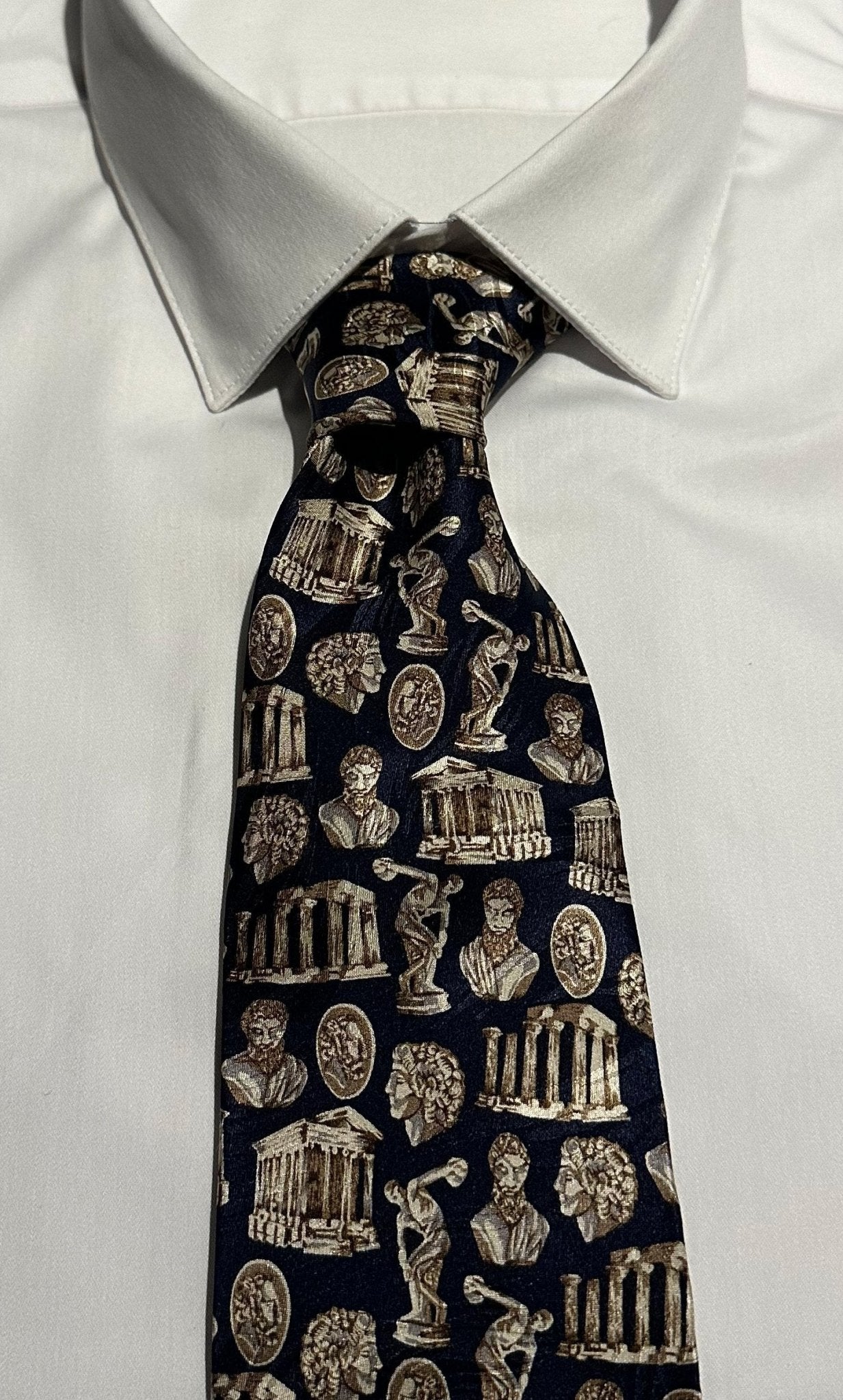 Navy tie with classical Greek architecture and busts pattern on a white shirt